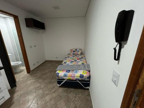 a small bedroom with a bed and a television at Condomínio Residencial Vitória 3 in Sao Paulo