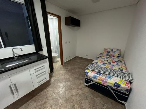a small room with a bed and a sink at Condomínio Residencial Vitória 3 in Sao Paulo