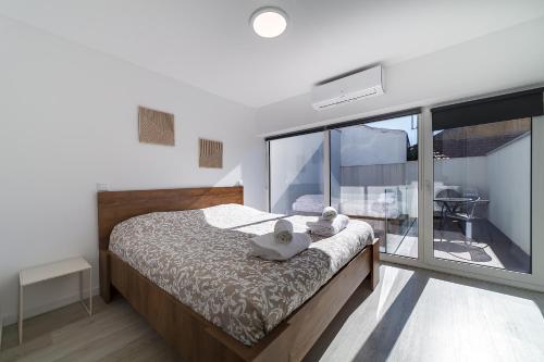 ein Schlafzimmer mit einem Bett mit zwei Stofftieren darauf in der Unterkunft Casinha da Rita by Home Sweet Home Aveiro in Aveiro