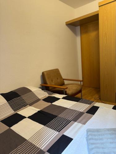 a bedroom with a bed and a chair in a room at Fichtenzauber in St. Blasien