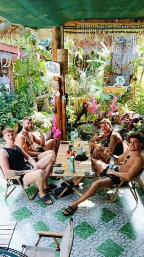 a group of men sitting in chairs in a garden at P P Garden Home Bungalow in Phi Phi Don