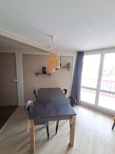 une salle à manger avec une table et des chaises noires dans l'établissement T2 apartment in residence with pool, à Le Touquet-Paris-Plage
