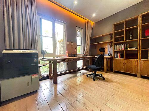 an office with a desk and a chair in a room at 哲帆民宿花园洋房江与城店 in Chongqing