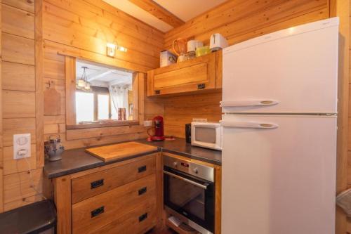 une cuisine avec un réfrigérateur et un micro-ondes dans l'établissement T3 chalet with terrace at the foot of the slopes, à Saint-Gervais-les-Bains