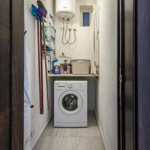 a small laundry room with a washing machine in it at Large & Modern 3BR Seafront Apartment with Large Balcony - Close to Saint Julian's, Sliema, & Manoel Island in Il-Gżira