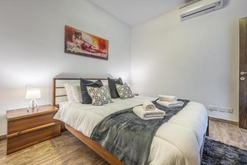 a bedroom with a large bed with pillows on it at Large & Modern 3BR Seafront Apartment with Large Balcony - Close to Saint Julian's, Sliema, & Manoel Island in Il-Gżira