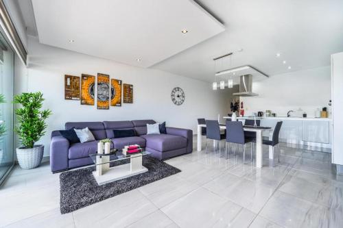 a living room with a purple couch and a table at Large & Modern 3BR Seafront Apartment with Large Balcony - Close to Saint Julian's, Sliema, & Manoel Island in Il-Gżira