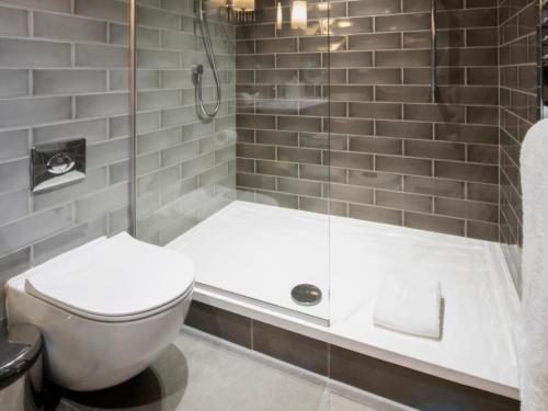 a bathroom with a toilet and a shower at Dakota Leeds in Leeds