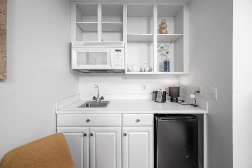 a white kitchen with a sink and a microwave at The Clubhouse Hideaway - The Greenview Den in Chapel Hill