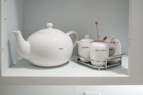 a shelf with two tea pots and a tea kettle at The Clubhouse Hideaway - The Greenview Den in Chapel Hill