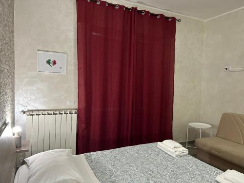 a bedroom with a red curtain and a bed at Guest House Il Faraone in Fiumicino