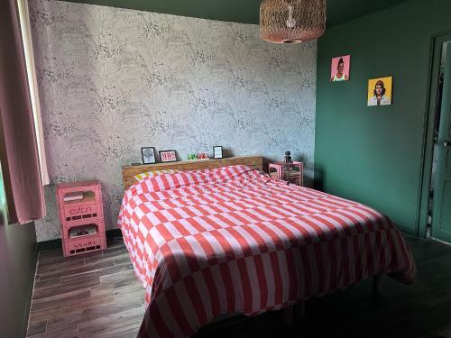 a bedroom with a bed with a red and white blanket at Idéal 24H du Mans - 3 chambres, jardin & stationnement facile in Saint Pavace