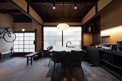 a kitchen with a table and chairs in a room at 町家旅館 航 HOTEL watari in Onomichi
