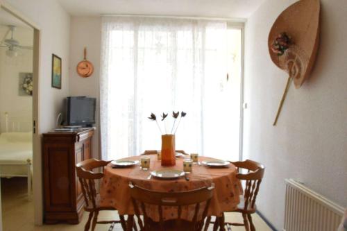 Cette chambre dispose d'une table avec des chaises et d'une fenêtre. dans l'établissement NP080-E102 Appartement 2 pièces Narbonne Plage, à Narbonne-Plage