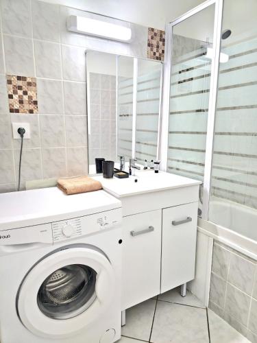 une salle de bain avec une machine à laver et un lavabo dans l'établissement Tour Nord - T3 entre Bastide et Cité medievale, à Carcassonne