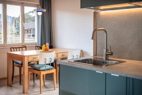 a kitchen with a sink and a table at Pool Apartments Edith in Lana