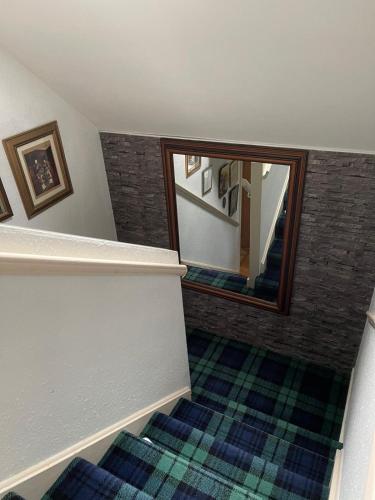 a hallway with a stairway with a mirror and a stair tread at Last House B4 The Sea in Garrabost