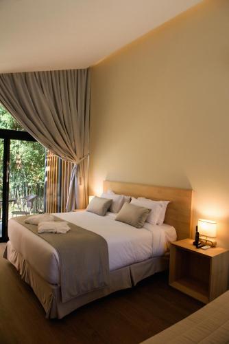 a bedroom with a large bed and a window at Hotel Boutique Vinícola Araucária by Slaviero Hotéis in São José dos Pinhais