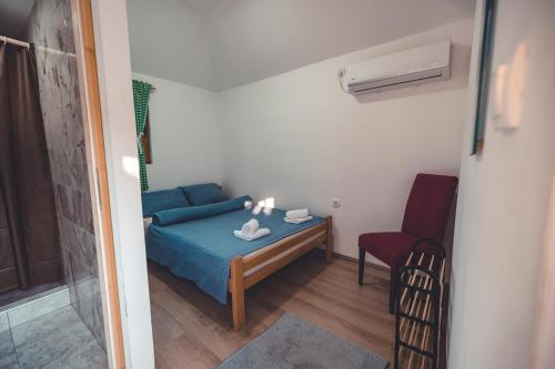 a small bedroom with a blue bed and a red chair at Konak Dobri Potok in Krupanj