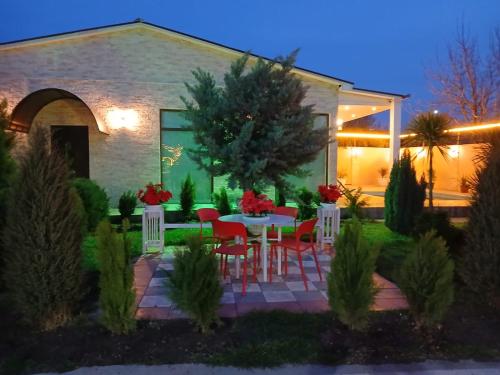 a patio with a table and chairs in front of a house at Green Land in Tbilisi City