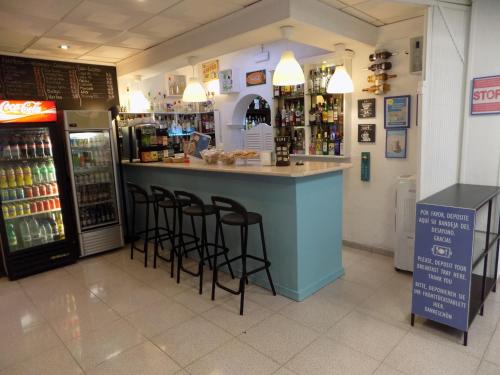 a bar in a store with stools at a counter at Hostal Villa Maruja in El Arenal