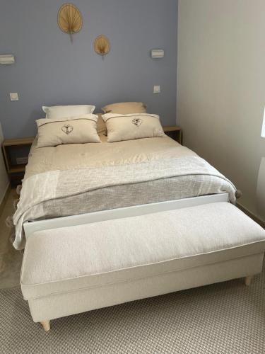 une chambre avec un lit avec des draps blancs et des oreillers dans l'établissement Appartement calme et chaleureux, à Saint-Germain-du-Bois