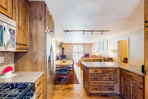 a kitchen with wooden cabinets and a living room at Lake Fork 10 in Taos Ski Valley
