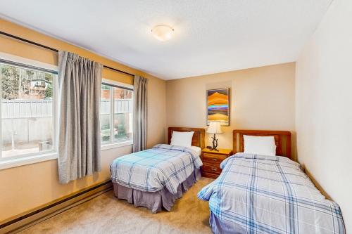 two beds in a room with two windows at Lake Fork 10 in Taos Ski Valley