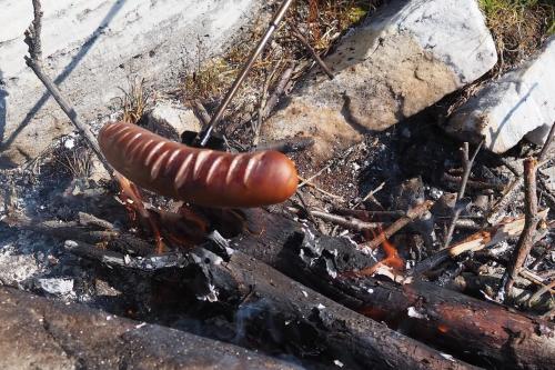 a sausage sitting on top of a fire at Bella Karnes in Oksevik