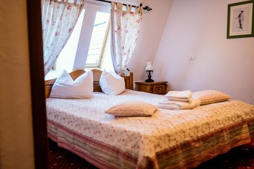 a bedroom with a bed with pillows and a window at Pensiunea Casa Motului in Arieşeni