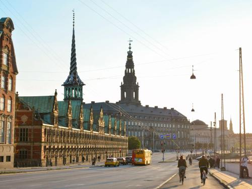 a city street with buildings and people riding bikes at Sanders Tivoli 1- Lovely 2-Bdr Apt near Tivoli in Copenhagen