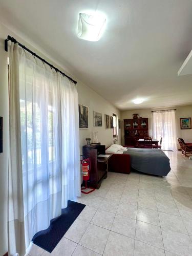 a living room with white curtains and a couch at Appartamento tra il borgo e il lago in Anguillara Sabazia