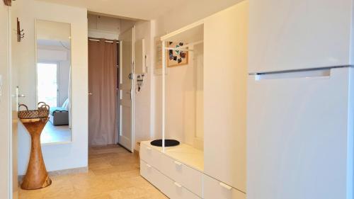 Cette chambre comprend une commode avec un vase. dans l'établissement Apartbleuazur - Bel appartement rénové piscine & vue mer, à Cavalaire-sur-Mer