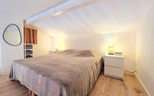 une chambre avec un grand lit et un miroir dans l'établissement Apartbleuazur - Bel appartement rénové piscine & vue mer, à Cavalaire-sur-Mer