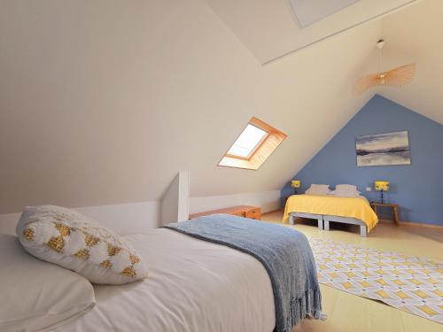 a bedroom with a white bed with a blue wall at Relais des îles Saint Marcouf in Saint-Marcouf