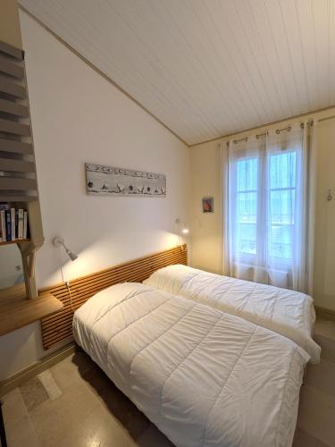 une chambre avec deux lits et une fenêtre dans l'établissement Appartement Neptune, à Saint-Martin-de-Ré