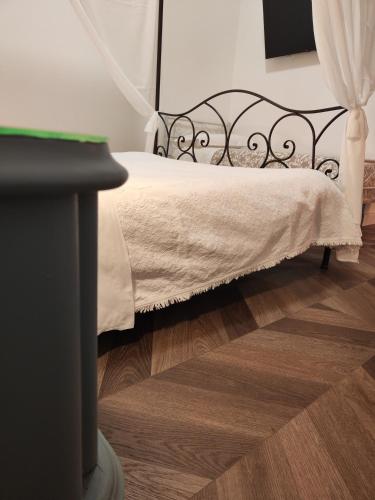 a bed with a black frame and a wooden floor at Botanica Loft in Montichiari Airport