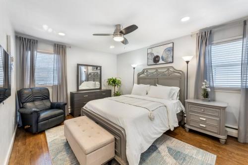 ein Schlafzimmer mit einem großen Bett und einem Stuhl in der Unterkunft Suburban 3BR Stylish Oasis in Maplewood