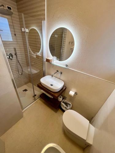 a bathroom with a toilet and a sink and a shower at Hotel Nuova Sabrina in Marina di Pietrasanta