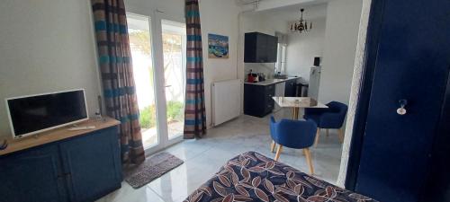 un salon avec une télévision et une table avec une chaise dans l'établissement Appartement avec jardin et spa, à Valras-Plage