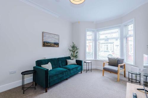 a living room with a green couch and chairs at Spacious & Modern House in Crewe by 53 Degrees Property, Ideal for Long Term, Sleeps 8! in Crewe