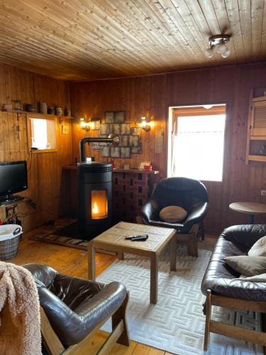 a living room with a fireplace and a couch and a table at Authentiek, Vintage Chalet aan de Bosrand in Weyer