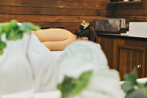 a woman sitting at a counter in a room at Hotel Boutique Vinícola Araucária by Slaviero Hotéis in São José dos Pinhais