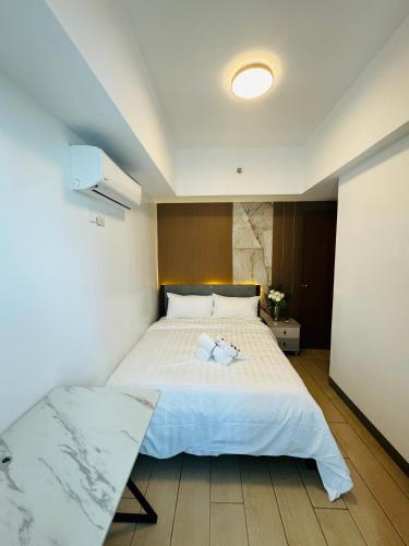a bedroom with a bed with two towels on it at Venetian Panorama BGC Venice Grand Canal Apart ment, 4 Bedrooms, for 10 Guests in Manila