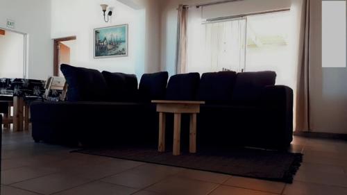 a black couch with a table in a living room at 1801 on Brandberg in Hentiesbaai