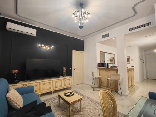 a living room with a blue couch and a flat screen tv at Aparthotel Dei Mercanti in Milan