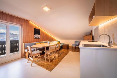 a kitchen and dining room with a table and chairs at Pool Apartments Edith in Lana