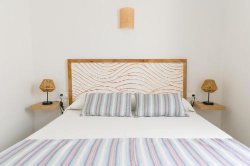 a bedroom with a bed with two lamps on two tables at Villa 10 Marias in Cala Blanca