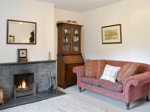a living room with a couch and a fireplace at Roundhill Cottages 1 in Grasmere