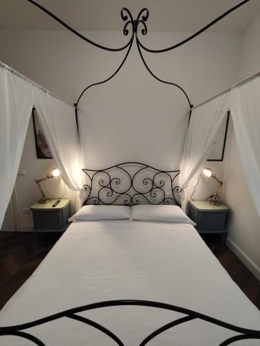 a bedroom with a black and white bed with two lamps at Botanica Loft in Montichiari Airport